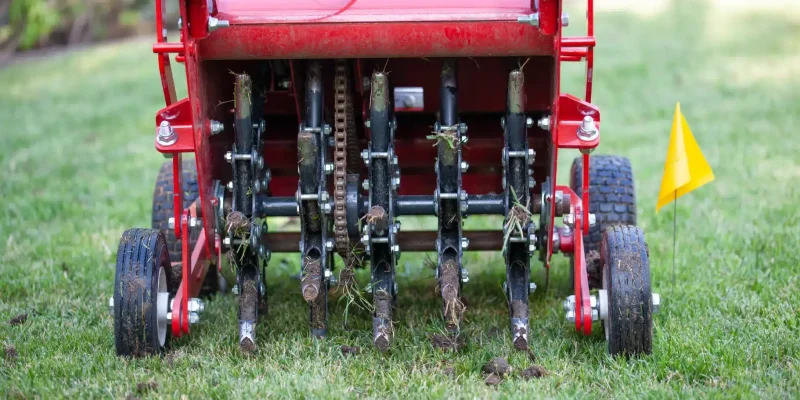 Red machine aerating a lawn in Omaha, Nebraska.